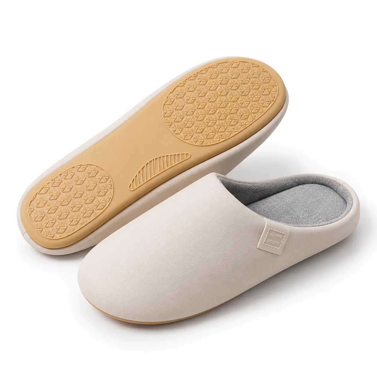 Deux chaussons beiges, dont un retourné montrant la semelle couleur gomme et ses motifs en relief.