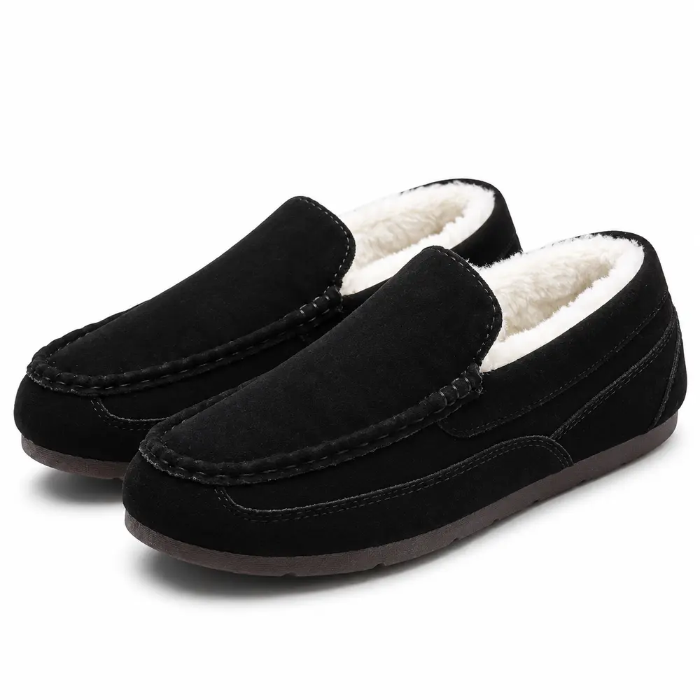 Paire de chaussons mocassins noirs à talon fermé, avec coutures apparentes et doublure claire.