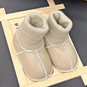Chaussons bébé en cuir souple beige sur fond blanc