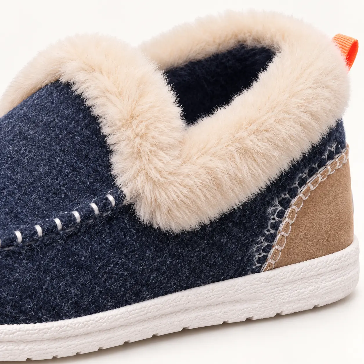 Chaussons bleu marine vus du dessus, avec col beige, intérieur sombre et coutures autour de l’avant du pied.